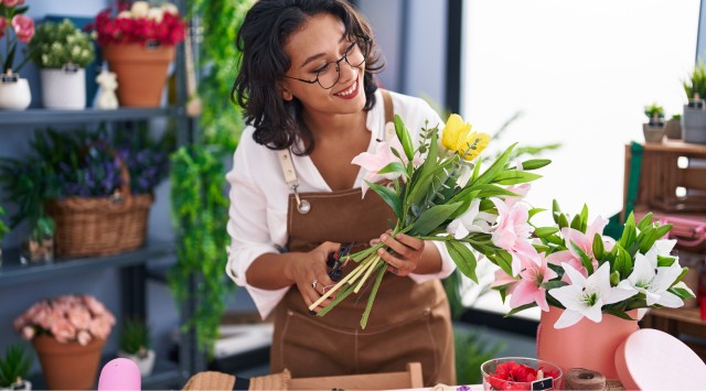 Smiling florist cutting flowers