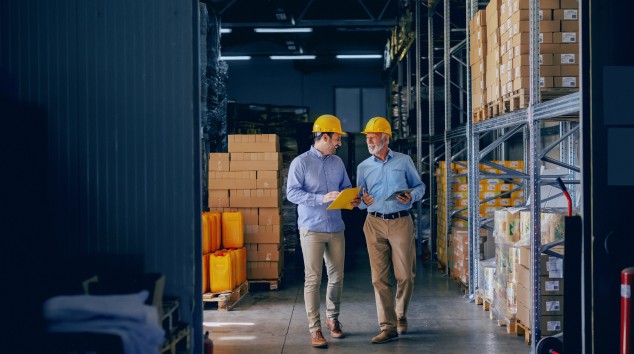 Men in hard hats walking in a warehouse