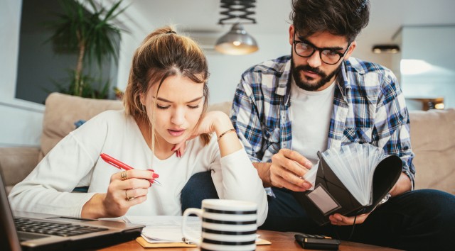 young couple sitting and looking at notebooks