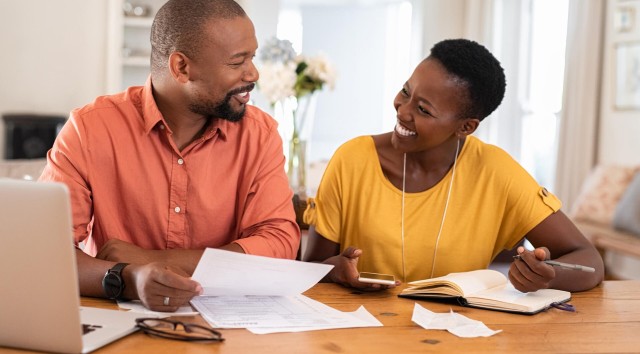 middle aged couple sitting at a table doing paperwork