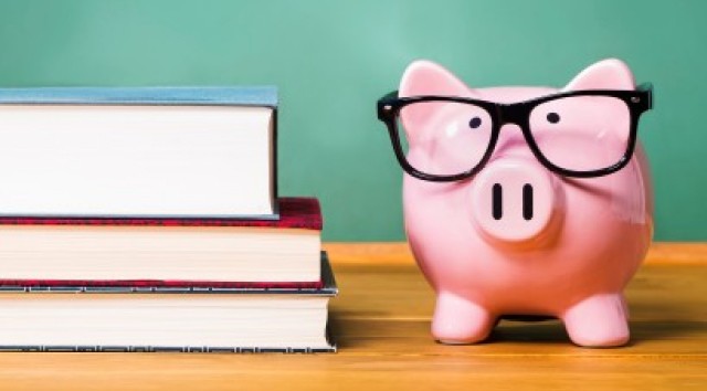 piggy bank wearing glasses next to a stack of books