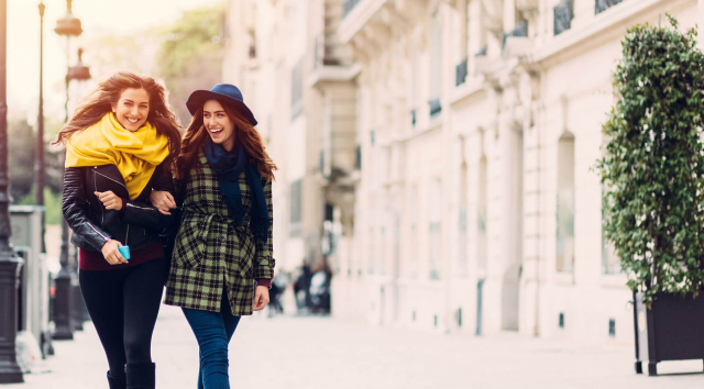 Two happy women walking in the city.