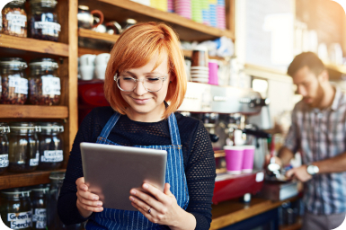 Barista looking at tablet in coffee shop