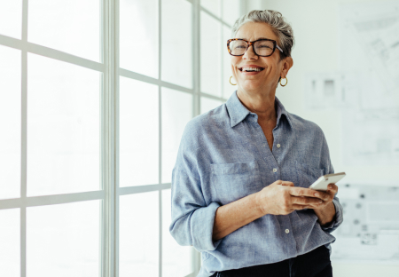Older woman standing by windows smiling