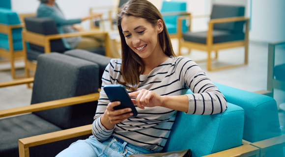 Young woman on mobile phone while sitting in a waiting area